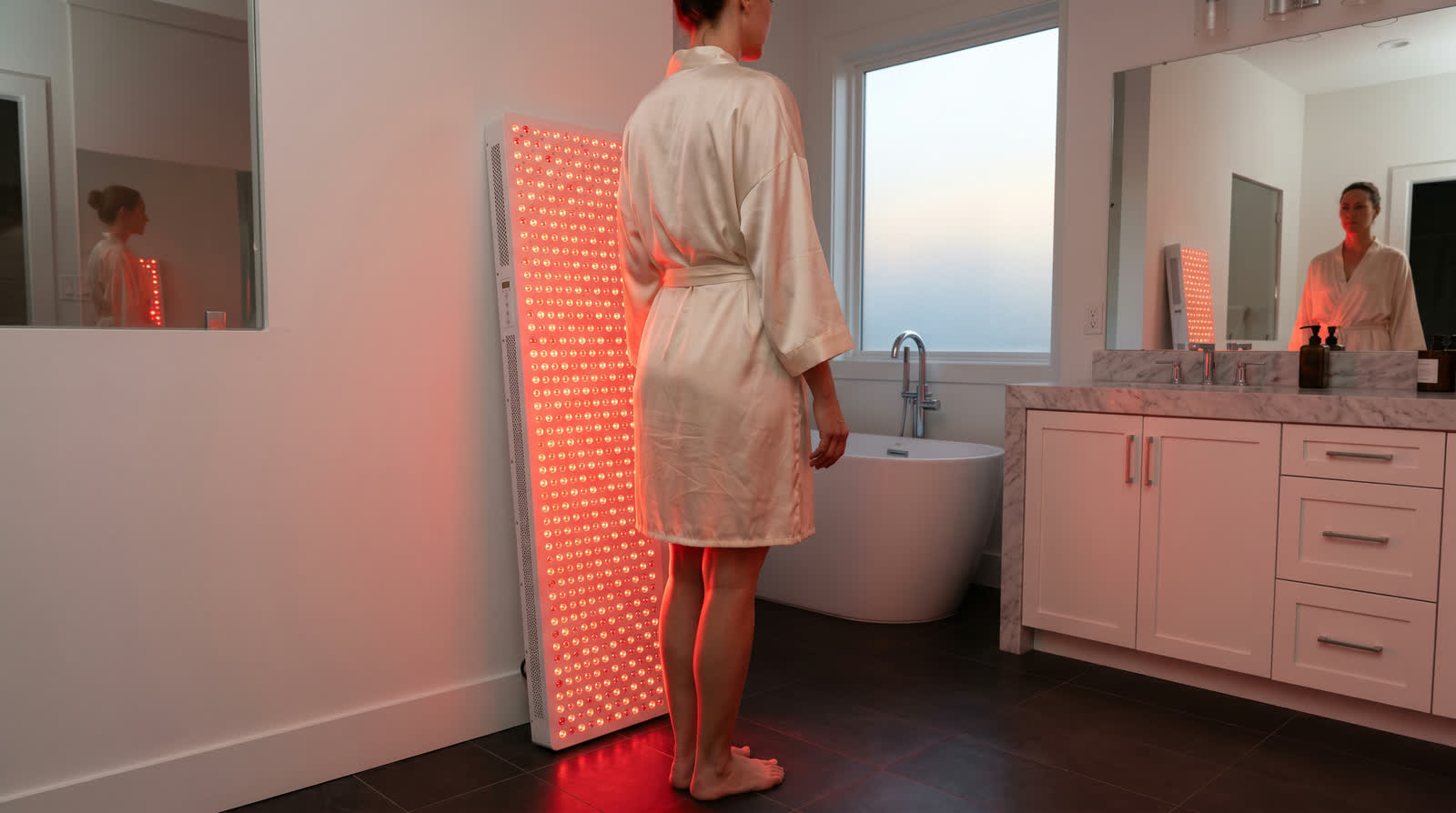 Woman in morning light beside the full-size Elite panel on its stand